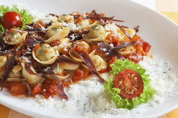 Tortellini in a red sauce with garnish
