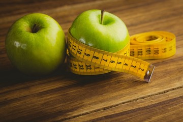 Green apples with measuring tape