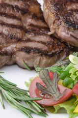 Grilled meat with salad at white plate