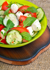 Fresh salad with mozarella cheese, tomatos, cucumber and arugula