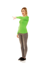 Shocked woman pointing aside.