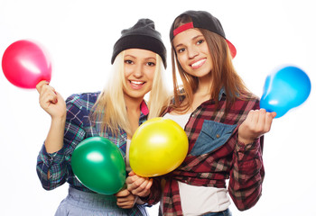 Fototapeta na wymiar hipster girls smiling and holding colored balloons
