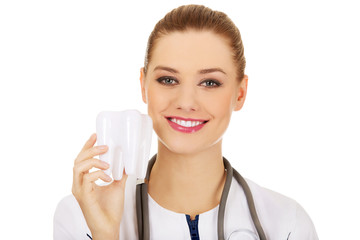Female dentist holding a tooth model.