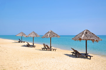 Obraz na płótnie Canvas Beach chairs and umbrellas on a beautiful panoramic beach view a