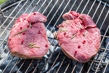 Roasting red beef with rosemary on grill