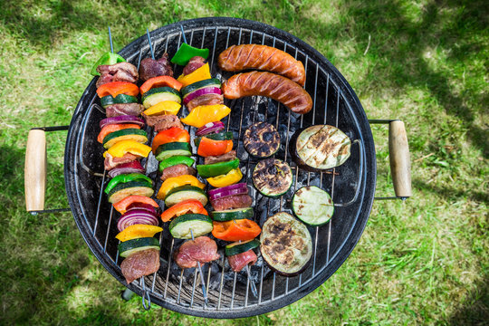 Grilling fresh vegetables and meat with herbs in garden