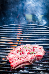 Grilling fresh beef with herbs and pepper