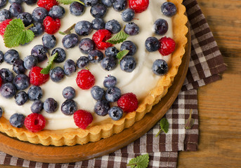 Cake with  blueberries on a wooden board.