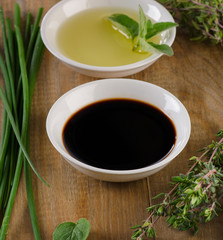 Obraz na płótnie Canvas Olive oil, balsamic vinegar and herbs on vintage wood backgroun