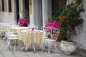 Fototapeta na wymiar Little Italian terrace with stylish white chair and flowers.