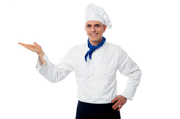 Smiling male chef showing something
