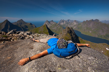 Fototapeta premium Man takes rest on top of mountain in Norway