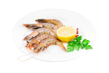 Raw shrimps on plate with lemon.