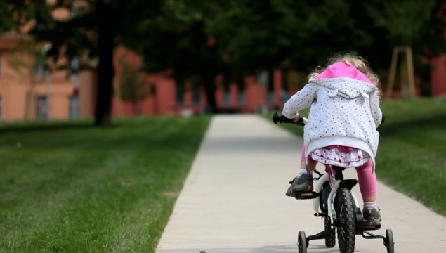 Little girl learning to ride a bike
