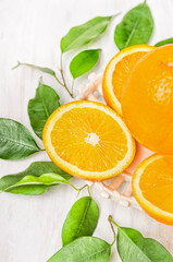 Orange fruits sliced with green leaves, close up
