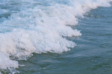 blue sea water waves background near coastline in sunset light
