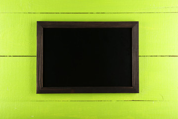 Wood frame on green wooden background