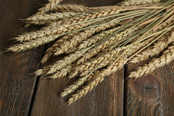 Wheat ears on brown wooden background