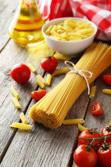 Spaghetti with pasta and tomatoes on wooden background