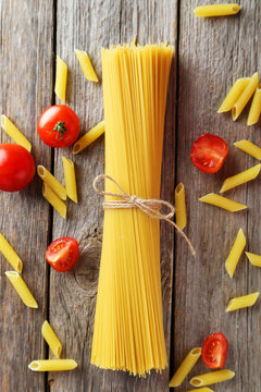 Spaghetti with tomatoes on grey wooden background
