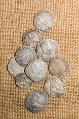 Ancient silver coins with portraits of kings on the old cloth