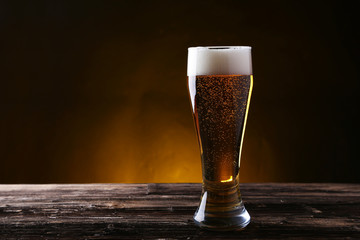 Glass of beer on brown wooden background