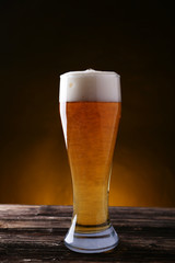 Glass of beer on brown wooden background