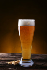 Glass of beer on brown wooden background