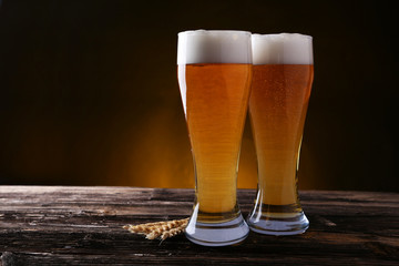 Two glass of beer on brown wooden background
