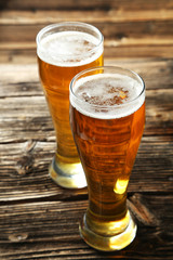 Two glass of beer on brown wooden background