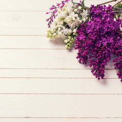 Lilac flowers on wooden background.