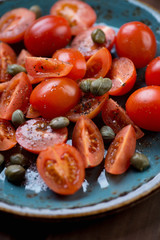 Close-up of cherry tomatoes with capers, sea salt and pepper