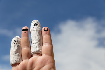 Hand vor blauem Himmel, eingegipste Finger