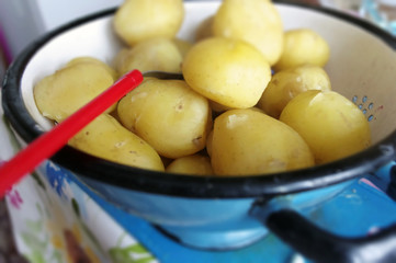 Obrane ziemniaki w niebieskim durszlaku w stylu vintage