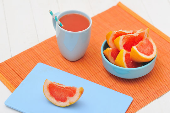 Grapefruit cut in slices and a cup of fresh joice