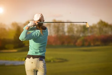 Foto auf Acrylglas Golf Frauengolfspieler, der Ball schlägt.