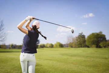 Tableaux ronds sur aluminium brossé Golf Woman golf player teeing off.