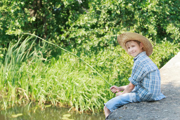 Angling boy with wooden rustic fishing rod