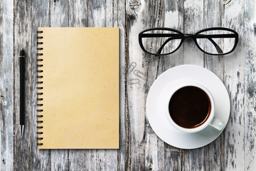 Blank diary and coffee cup on a vintage wooden table, mock up