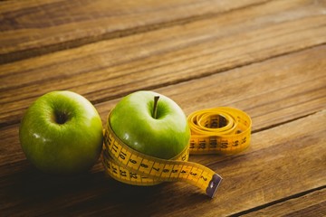 Green apples with measuring tape