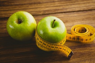 Green apples with measuring tape