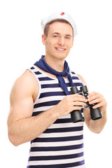 Male sailor holding binoculars and smiling