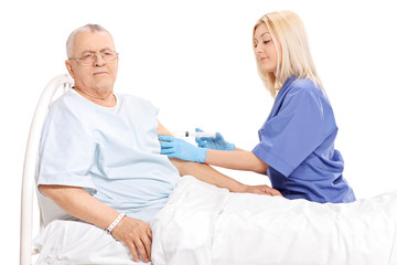 Female doctor giving an injection to a mature patient