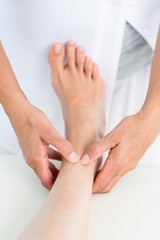 Physiotherapist massaging her patients ankle