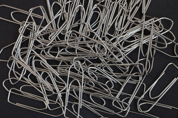 metal paper clips on a black background