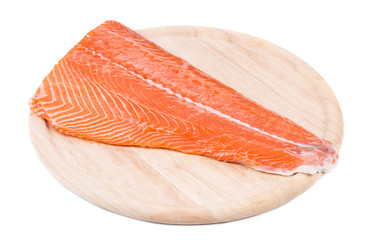 Raw salmon fillet on wood platter.