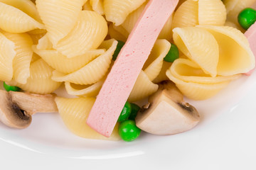 Pasta shells with vegetables on plate.