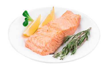 Fried salmon fillet on plate with lemon.