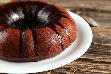Chocolate pie on white plate on brown wooden background