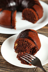 Slice of chocolate pie on white plate on wooden background